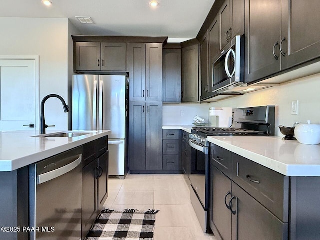 5744 E Killen Loop, Prescott Valley, AZ 86314 - kitchen featuring stainless steel appliances, a sink, light countertops, light tile patterned flooring, and an island with sink