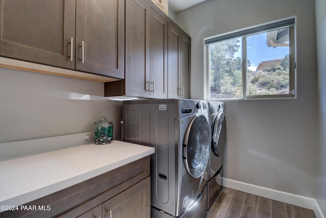 laundry room featuring washer and clothes dryer, cabinets, and hardwood / wood-style flooring