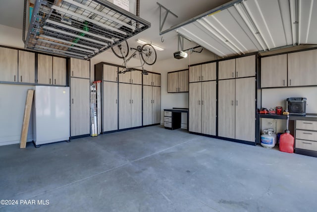 garage featuring white refrigerator and a garage door opener