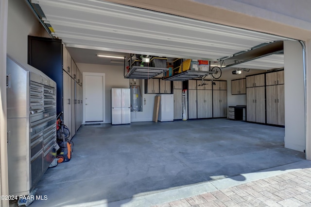 garage featuring white refrigerator, a garage door opener, and water heater