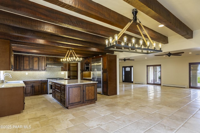 kitchen with ceiling fan with notable chandelier, under cabinet range hood, open floor plan, baseboard heating, and high end appliances