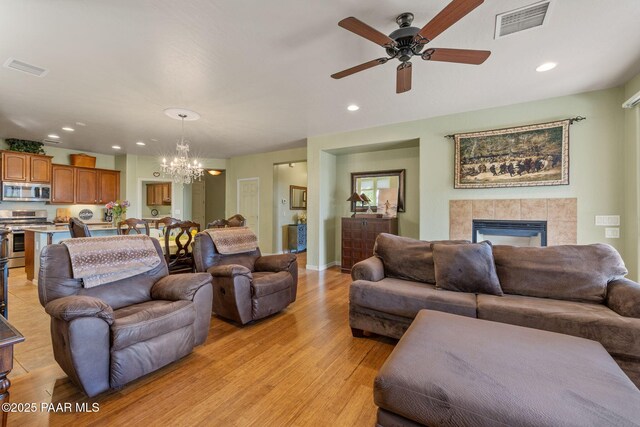 1109 N Half Hitch Rd, Prescott Valley, AZ 86314 - living area featuring a chandelier, light wood-type flooring, a ceiling fan, a tile fireplace, and recessed lighting