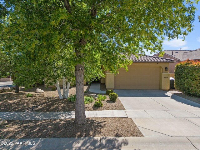 1109 N Half Hitch Rd, Prescott Valley, AZ 86314 - view of front facade with an attached garage, driveway, a tiled roof, and stucco siding