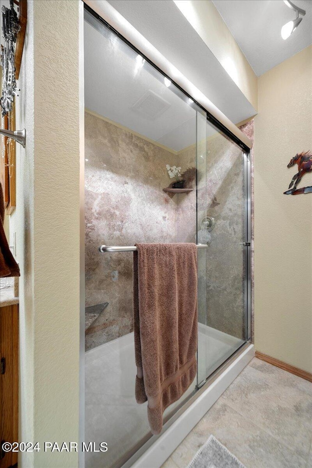 bathroom featuring a shower with door