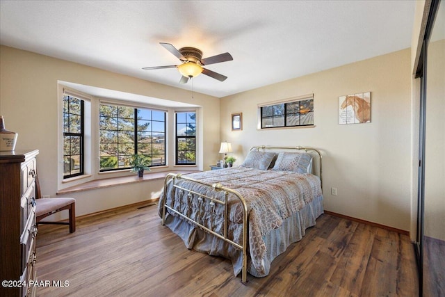 bedroom featuring ceiling fan, a closet, and hardwood / wood-style flooring