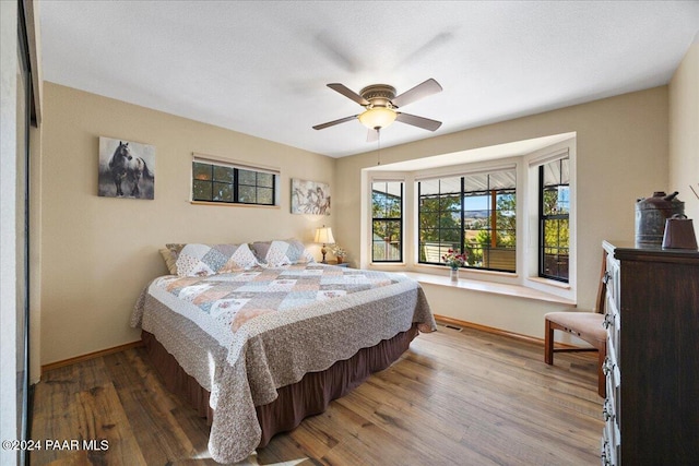 bedroom with ceiling fan and hardwood / wood-style flooring