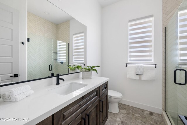 bathroom with vanity, an enclosed shower, and toilet