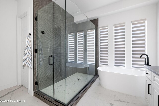 bathroom featuring vanity and independent shower and bath