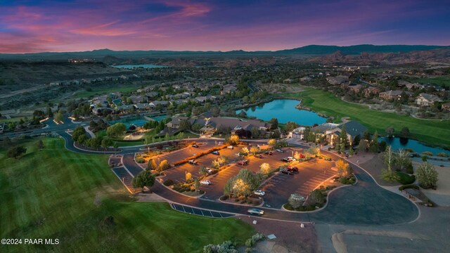 aerial view at dusk featuring a water and mountain view