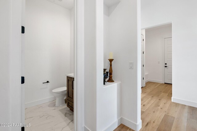 bathroom with hardwood / wood-style floors, vanity, and toilet