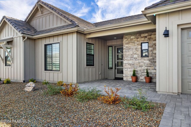 view of exterior entry with a patio