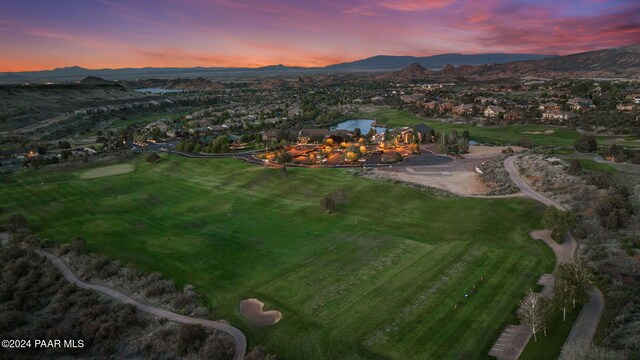 aerial view at dusk featuring a water and mountain view