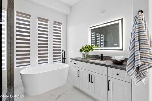 bathroom featuring vanity and a tub to relax in