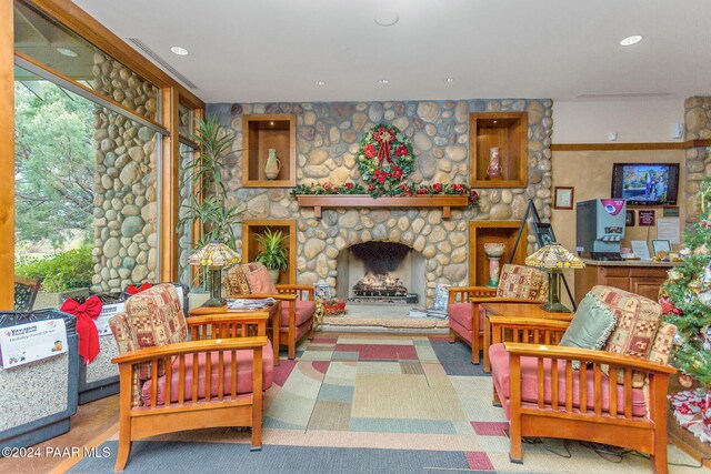 living room with a stone fireplace and carpet