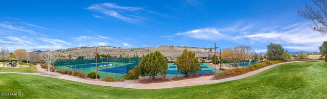 view of home's community featuring tennis court, a mountain view, and a yard