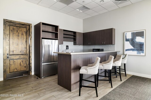 3280 Stone Cliff Ct, Prescott, AZ 86301 - kitchen featuring open shelves, freestanding refrigerator, light countertops, a kitchen breakfast bar, and a peninsula