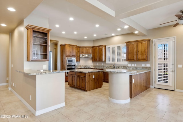 3280 Stone Cliff Ct, Prescott, AZ 86301 - kitchen featuring under cabinet range hood, appliances with stainless steel finishes, a peninsula, ceiling fan, and brown cabinetry