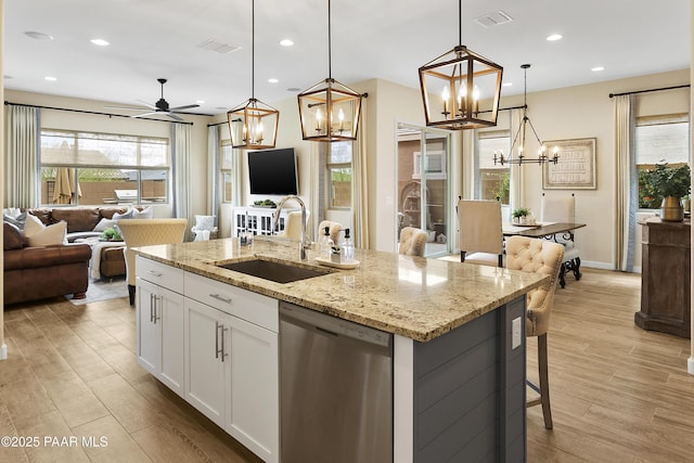 24757 N 175th Dr, Surprise, AZ 85387 - kitchen featuring a chandelier, open floor plan, stainless steel dishwasher, light wood-style flooring, and an island with sink