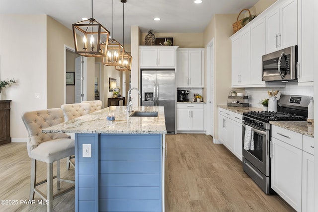 24757 N 175th Dr, Surprise, AZ 85387 - kitchen with stainless steel appliances, a chandelier, a kitchen bar, recessed lighting, and light wood finished floors