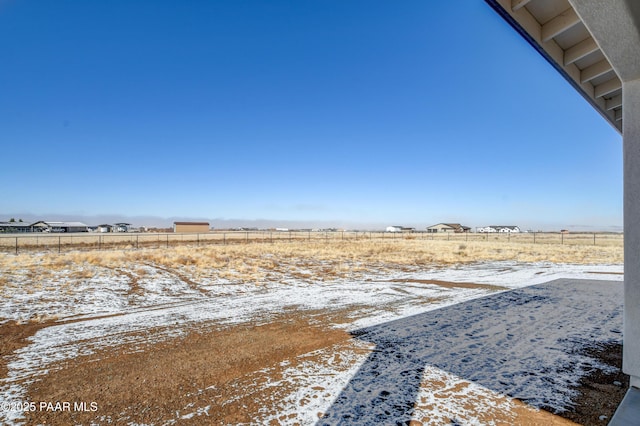 yard covered in snow with a rural view