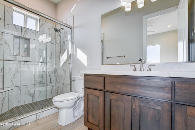 full bathroom featuring a marble finish shower, toilet, and vanity