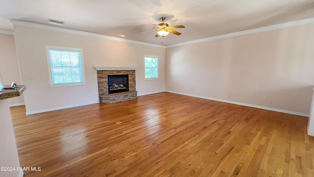 unfurnished living room featuring plenty of natural light, light hardwood / wood-style floors, and crown molding