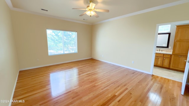 unfurnished room featuring ceiling fan, sink, ornamental molding, and light wood-type flooring