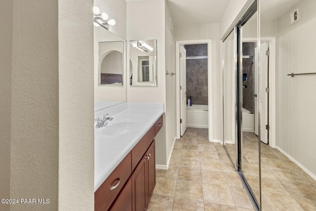 full bath with visible vents, vanity, baseboards, and walk in shower