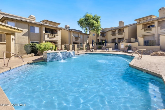 community pool featuring a residential view and fence