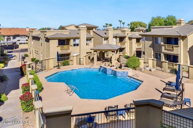 pool with a residential view, a patio area, and fence