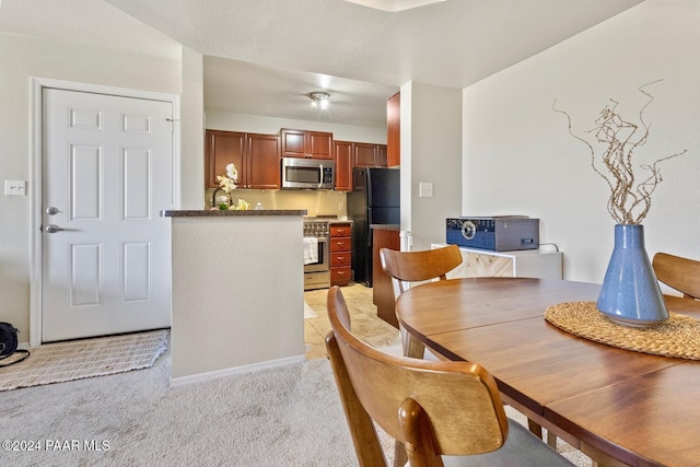 dining space featuring light carpet