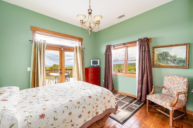 2667 N Overlook Dr, Williams, AZ 86046 - bedroom featuring access to outside, multiple windows, a chandelier, and wood finished floors