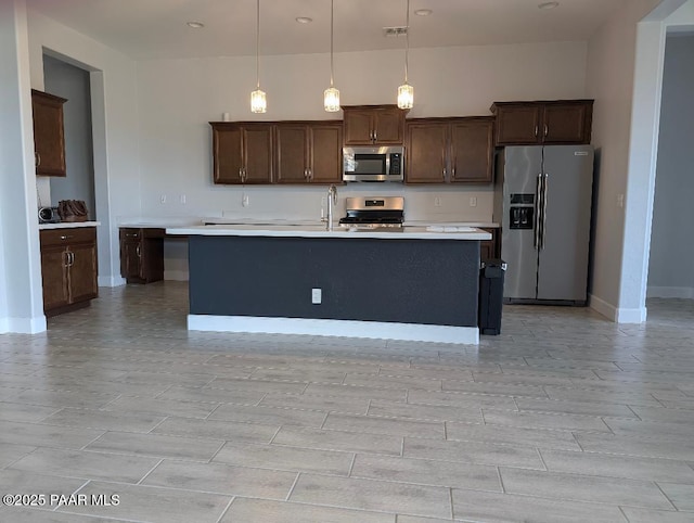 7942 E Carbon Ct Unit 20-A, Prescott Valley, AZ 86315 - kitchen with appliances with stainless steel finishes, light countertops, pendant lighting, dark brown cabinetry, and wood finish floors