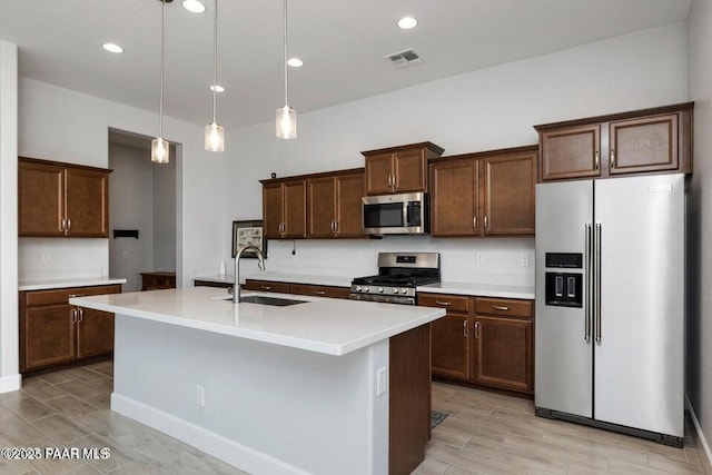 7942 E Carbon Ct Unit 20-A, Prescott Valley, AZ 86315 - kitchen with stainless steel appliances, light countertops, a center island with sink, dark brown cabinetry, and hanging light fixtures