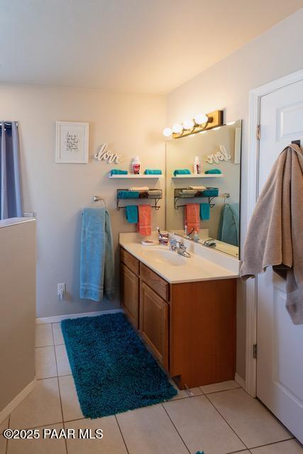 bathroom featuring tile patterned flooring, vanity, and baseboards