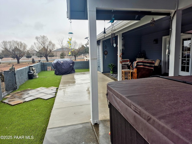 view of patio / terrace with grilling area, a fenced backyard, and a hot tub