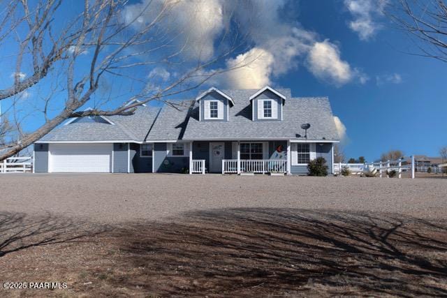 cape cod house featuring a garage, covered porch, and driveway