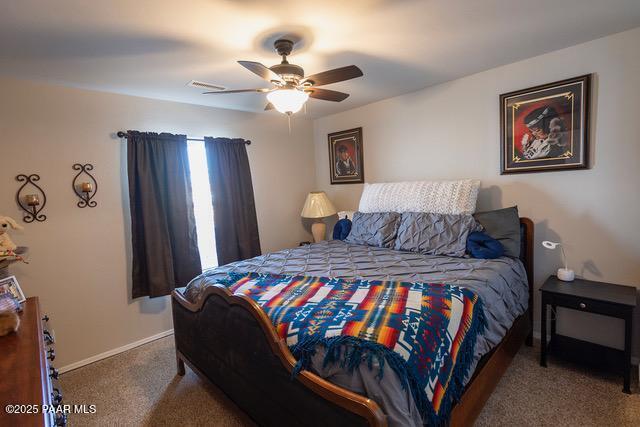 carpeted bedroom featuring ceiling fan and baseboards