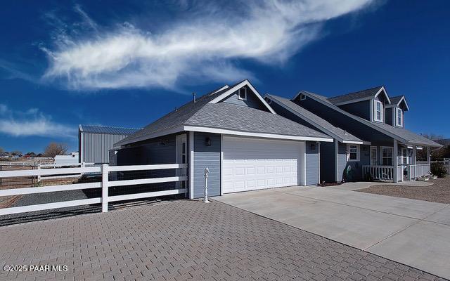 view of front of property with concrete driveway, a porch, fence, and a garage