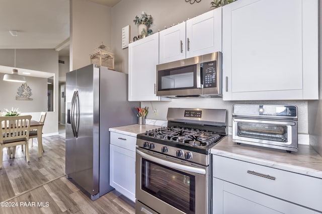 1665 Quail Run, Prescott, AZ 86303 - kitchen with white cabinets, light wood-type flooring, stainless steel appliances, and lofted ceiling