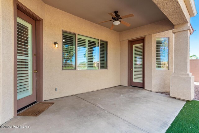 doorway to property with ceiling fan and a patio area