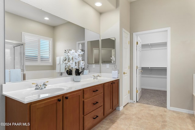 bathroom featuring tile patterned flooring, vanity, and a shower with door