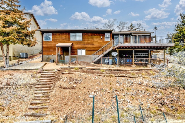 rear view of house with central AC unit, fence, stairway, and a deck
