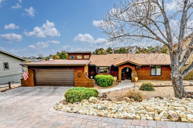 view of front facade with a garage and decorative driveway