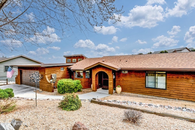 view of front of house featuring a shingled roof and an attached garage