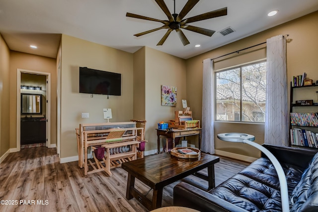 living room with a ceiling fan, wood finished floors, recessed lighting, and baseboards