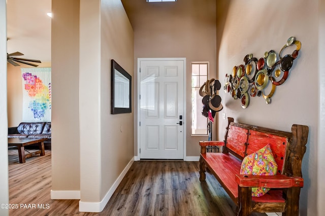 foyer with wood finished floors, baseboards, and a ceiling fan