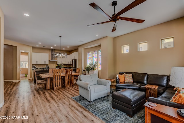 living room with plenty of natural light, a ceiling fan, light wood-type flooring, and recessed lighting