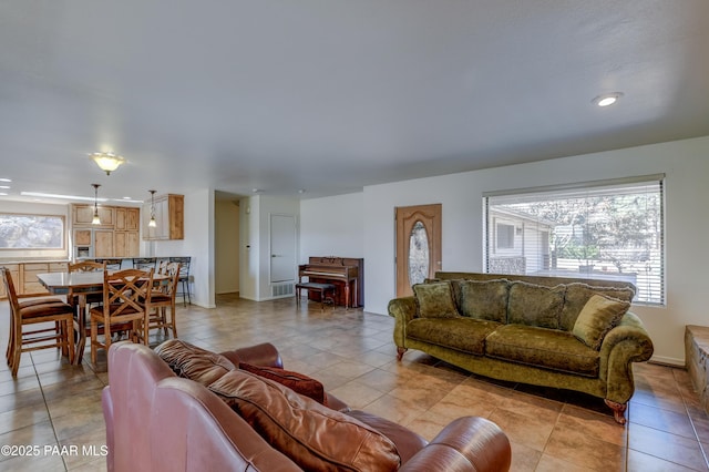 living area featuring light tile patterned floors, plenty of natural light, and baseboards