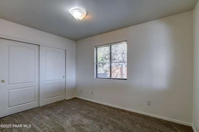 unfurnished bedroom with carpet floors, baseboards, and a closet